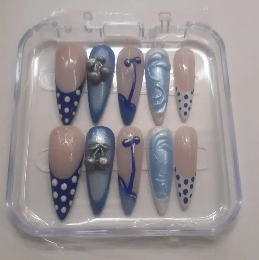 Set de 10 faux ongles Cherry Dreams  présentant des designs cerises avec motifs cerises , textures en nuances de bleu et beige, finition brillante professionnelle