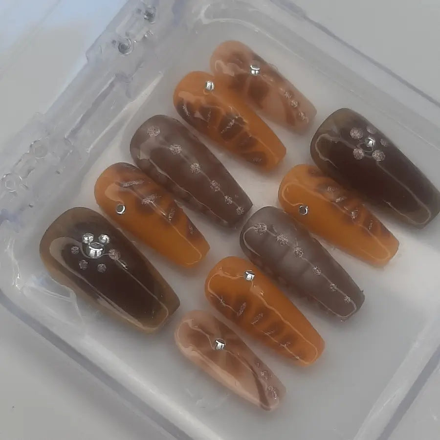 Faux ongles aux tons automnales marron foncé clair et strass