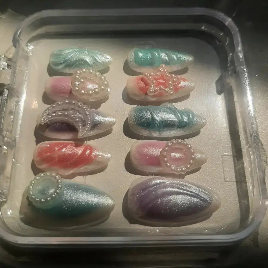 Faux ongles aux couleurs arc en ciel ornés de strass lune, coeur et rond