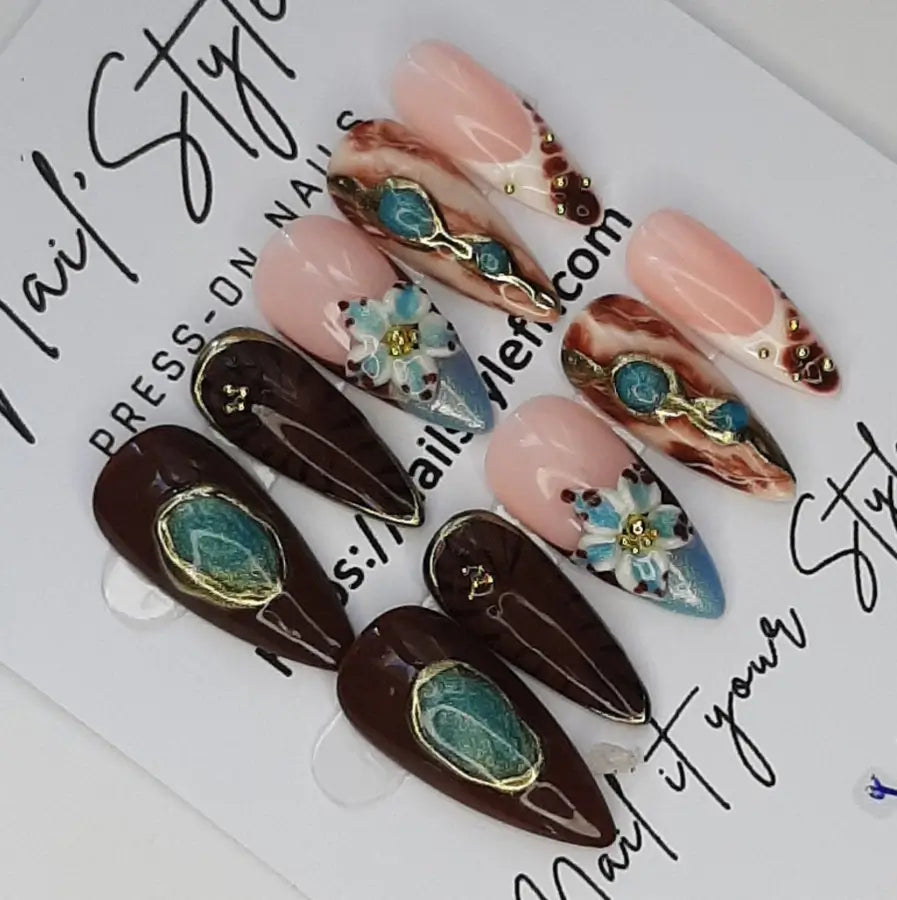 vue détaillée des faux ongles de forme stiletto marron et bleu sur une base nude