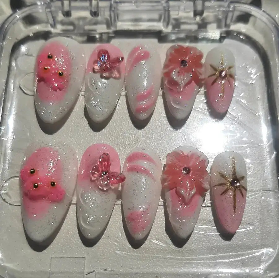 faux ongles Pink Blossom avec motifs floraux roses délicats, détails dorés et base blanche élégante