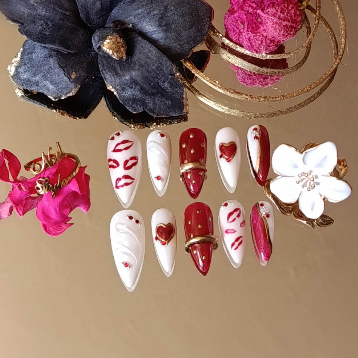 Vue détaillée de la poses valentine's, faux ongles réutilisables, press on nails faits main en France. Stiletto moyen. Rouge cat eyes et blanc, cœurs, lèvres et bague chrome doré