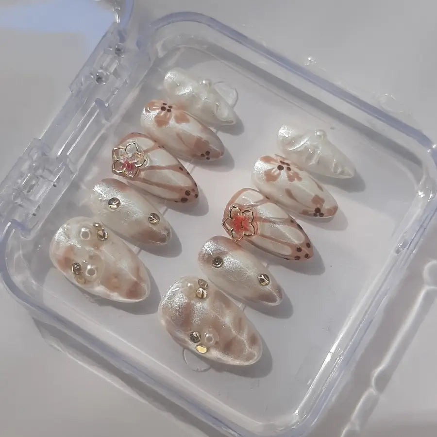 faux ongles nacré aux couleurs blanc et marron revêtue d'une fleur