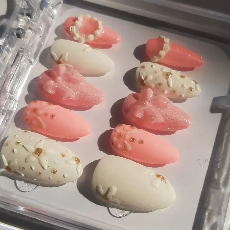 vue de côté révélant les tons nude, rose poudré, ornés de strass dorés et décorations scintillantes, disposés sur fond blanc mariage