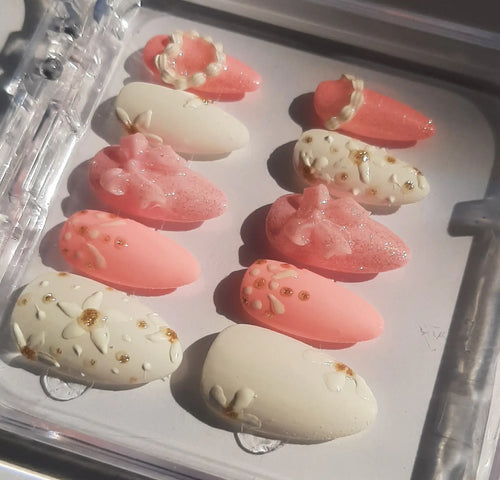 vue de côté révélant les tons nude, rose poudré, ornés de strass dorés et décorations scintillantes, disposés sur fond blanc mariage