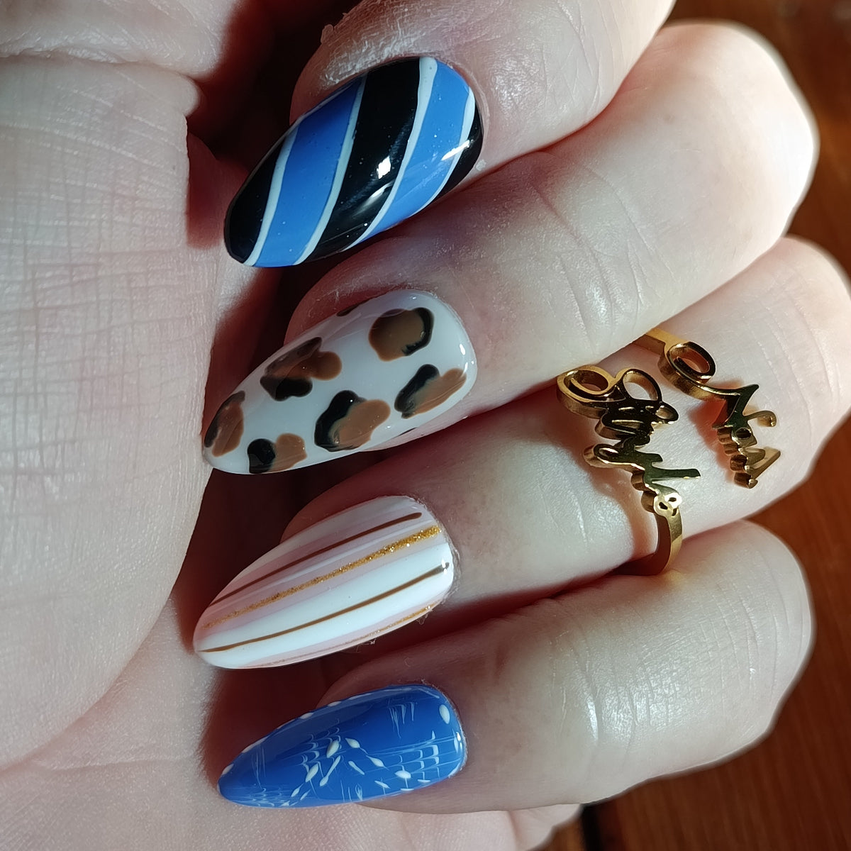 gros plan des press on nails, amande médium, bleu, blanc et noir, design léopard