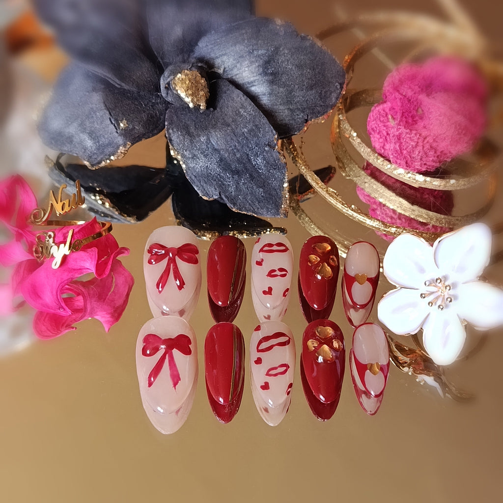 Press on nails faits main en France. Amande medium, rouge et nude, collection saint valentin, nœuds et lèvres, petits cœurs 