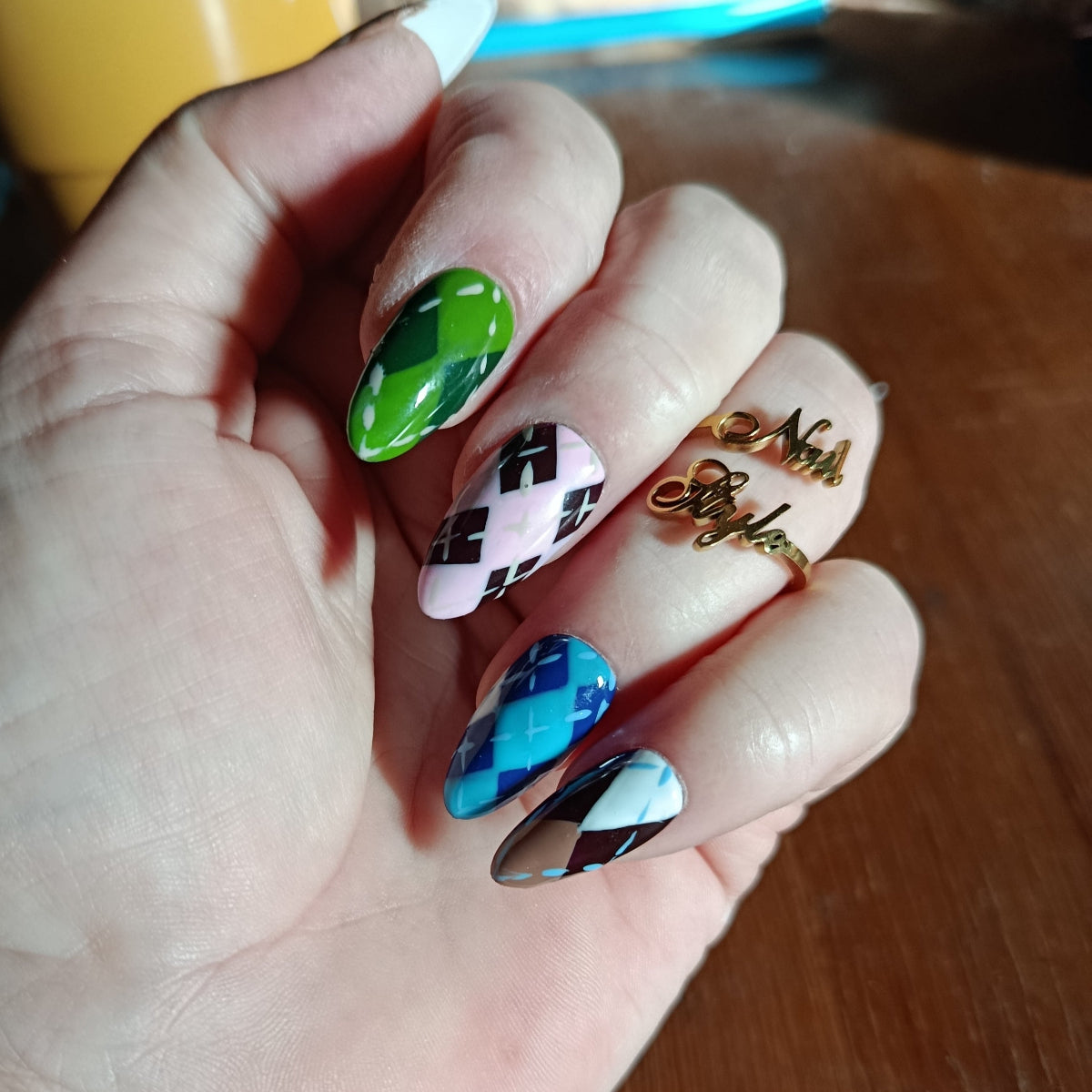 Vue détaillée des press on nails amande medium, jacquard français, artisanal. Aux couleurs bleu, marron, rose et blanc.