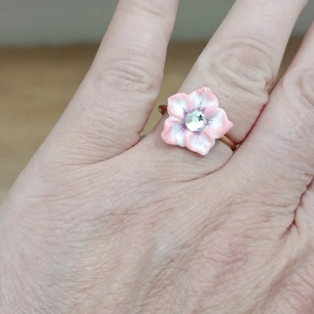 Bague Sand Rose portée à la main – fleur en résine rose poudré avec strass cristal, anneau doré rose, fabrication artisanale française