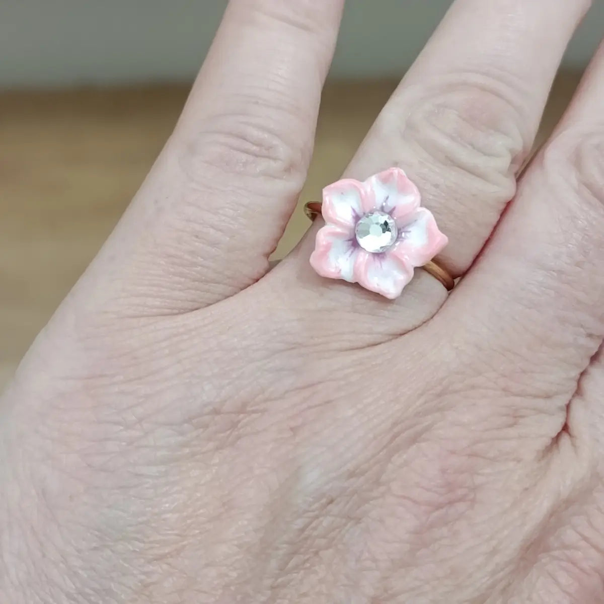 Bague Sand Rose portée à la main – fleur en résine rose poudré avec strass cristal, anneau doré rose, fabrication artisanale française