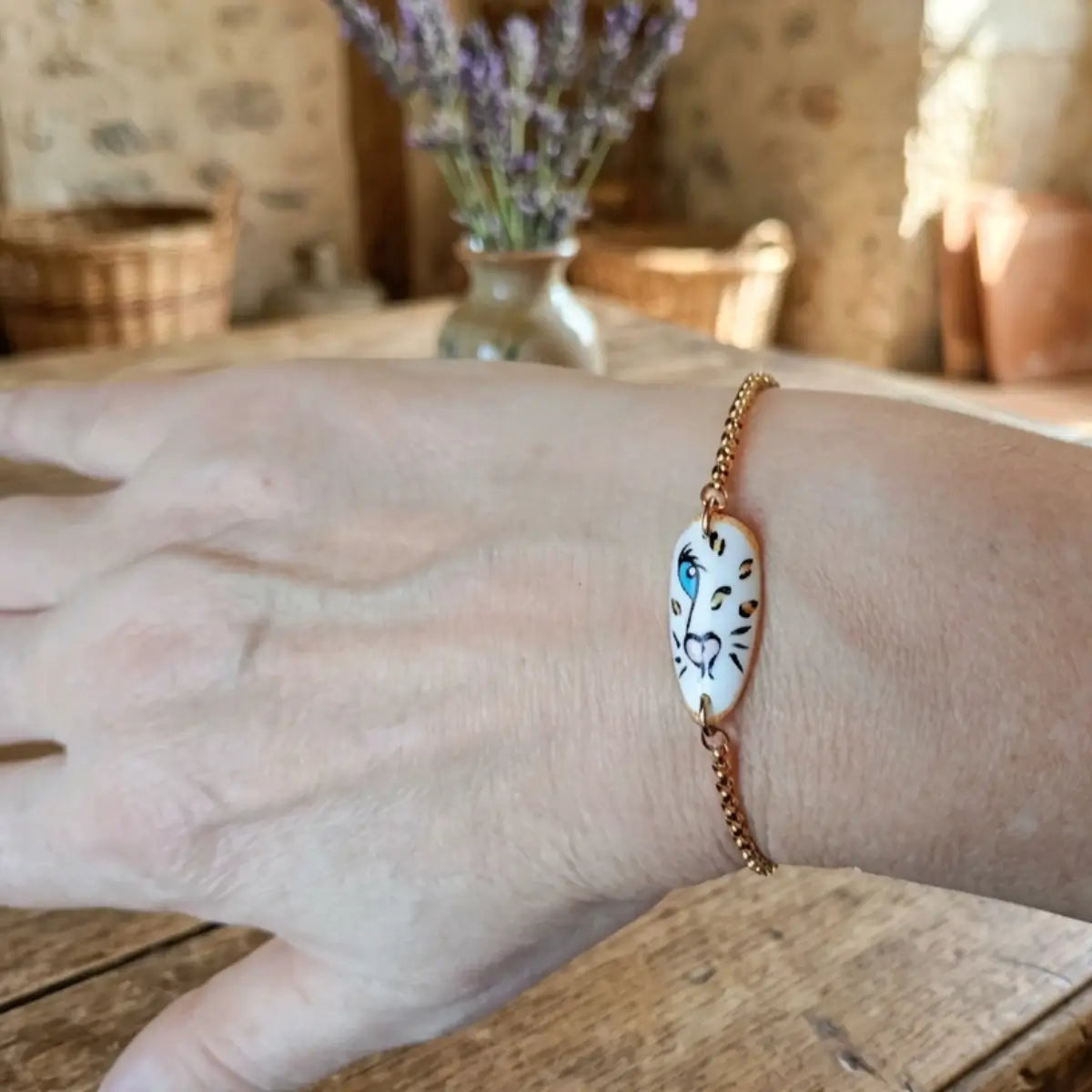 Bracelet chaîne dorée avec médaillon tigre blanc peint à la main, porté au poignet, style bohème artisanal