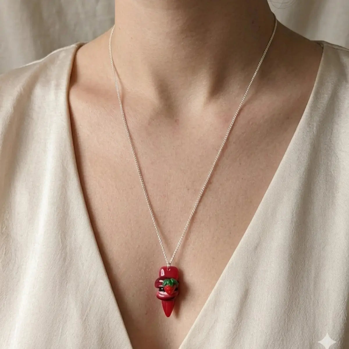 Collier pendentif lèvres rouges avec fraise en résine, porté sur chaîne argentée fine, style artisanal kawaii