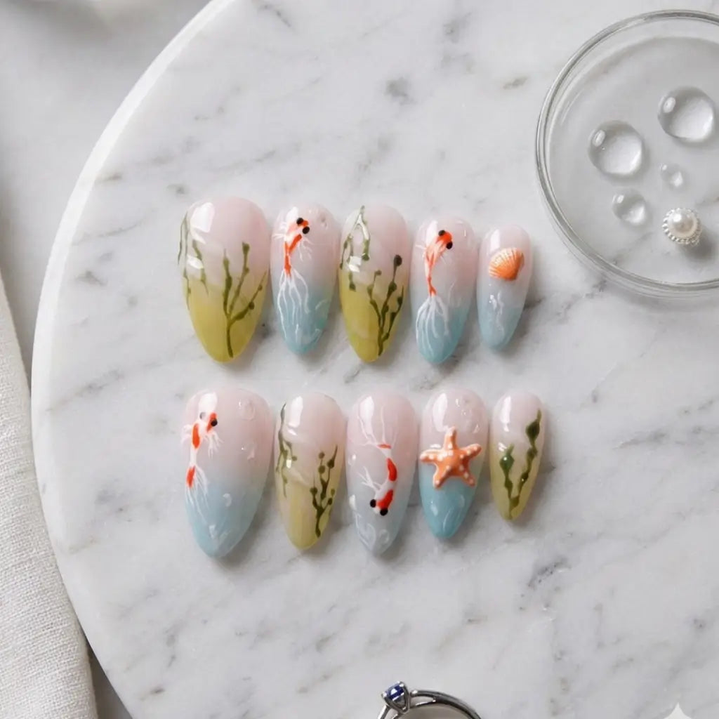 Faux ongles réutilisables Aqua Flora forme amande avec motifs aquatiques peints à la main, poissons et végétation marine.