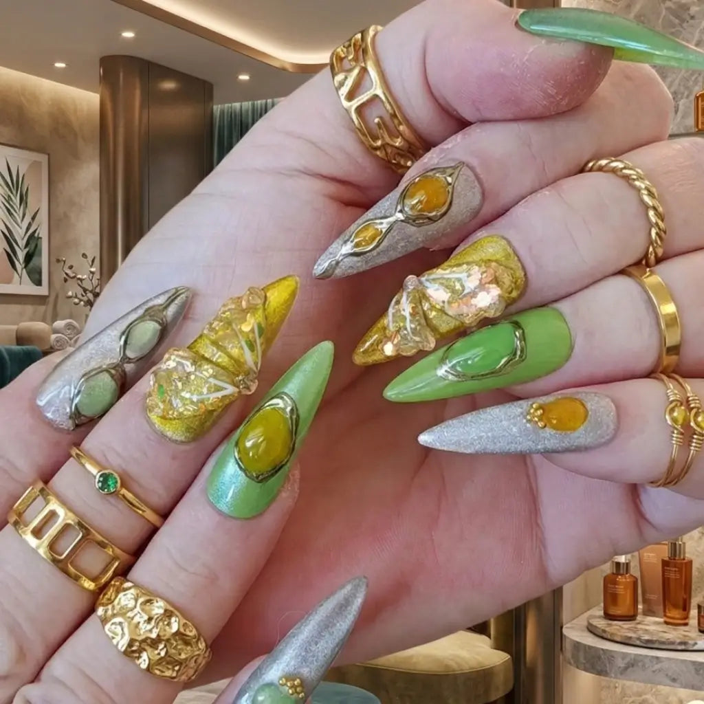 Faux ongles stiletto premium Jade Ambert - design vert émeraude et jaune ambre avec pierres précieuses et effet cat eye - nail art luxe fait main en France.