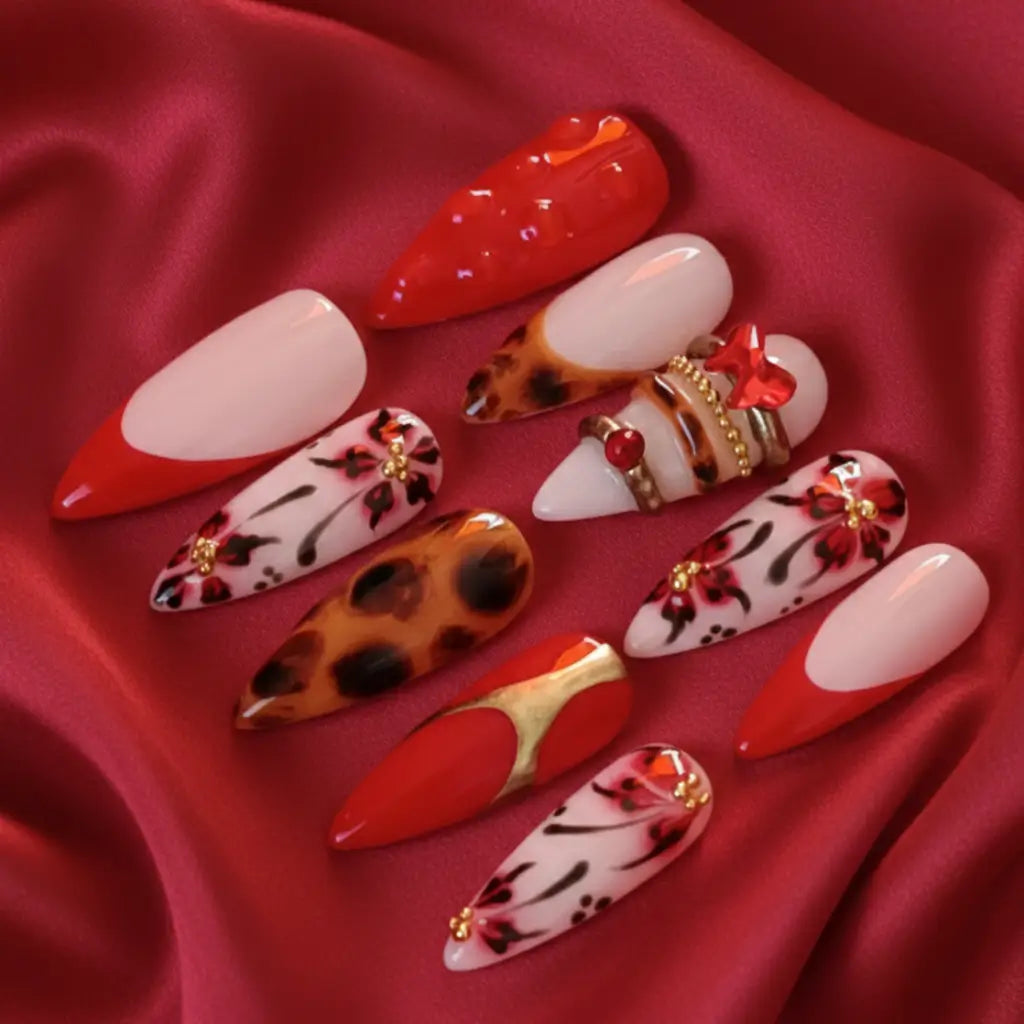 Press-on nails Kaylie rouge sur base nude avec strass dorés - set complet de 10 ongles. Livraison en France.