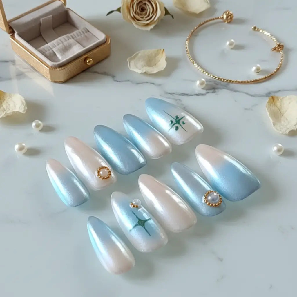 Faux ongles Perle de Ciel bleu clair et blanc nacré - présentation avec coffret doré et accessoires.