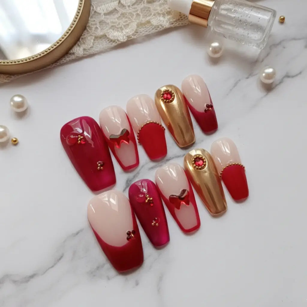 Set complet faux ongles Royal Garnet rouge et or, design sophistiqué avec strass et ornements.