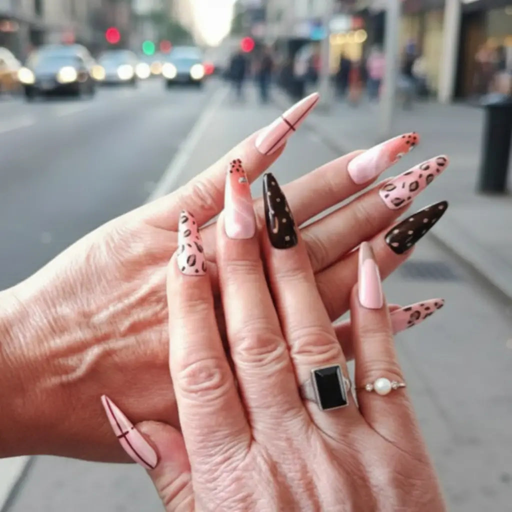 Press-on nails Vibes Only stiletto base nude - vue portée en extérieur avec motifs léopard et pois.