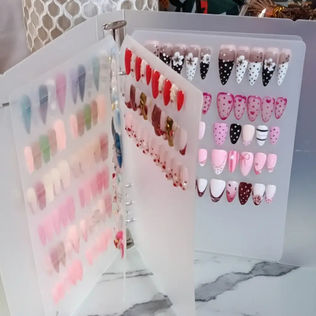Organisateur press-on nails ouvert présentant plusieurs collections de faux ongles réutilisables rangés par design