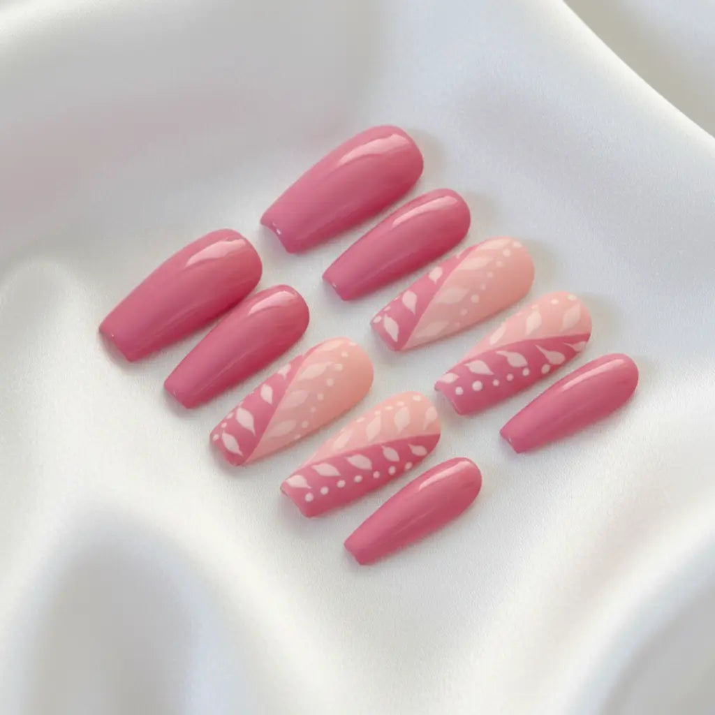 Faux ongles press-on Candy rose avec motifs floraux blancs, forme coffin longue, faits main en France.