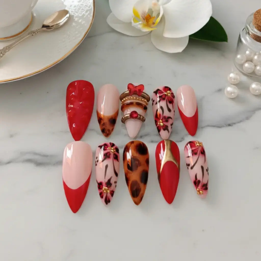 Faux ongles Kaylie forme stiletto rouge et nude avec motifs léopard et floraux dorés