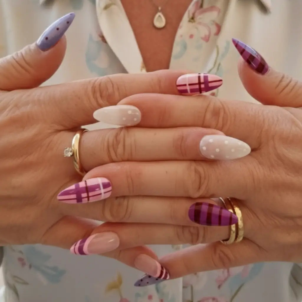 Faux ongles Plum Chic forme amande avec motifs carreaux rose et violet, rayures bordeaux et pois lilas.