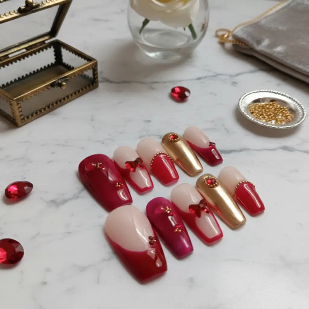 Press-on nails Royal Garnet rouge grenat et or avec strass, forme stiletto, fabriqués en France.