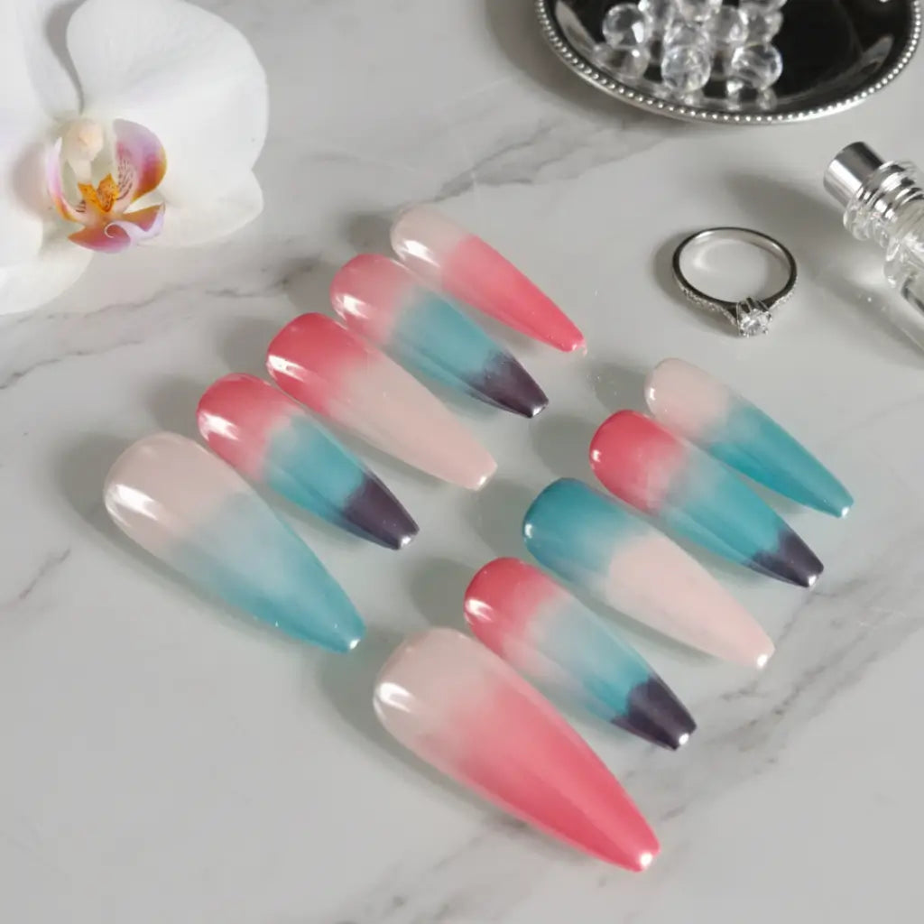 Press-on nails Sunset Lagoon forme coffin longue avec dégradé tropical rose et turquoise, ambiance spa luxe.