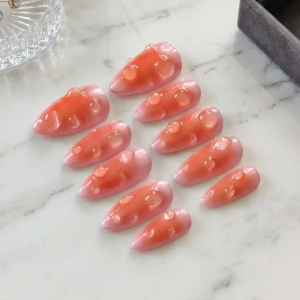 Set de press-on nails Velvet Peach posés sur marbre – faux ongles corail et pêche nacrée avec bulles en relief, forme amande, faits main en France