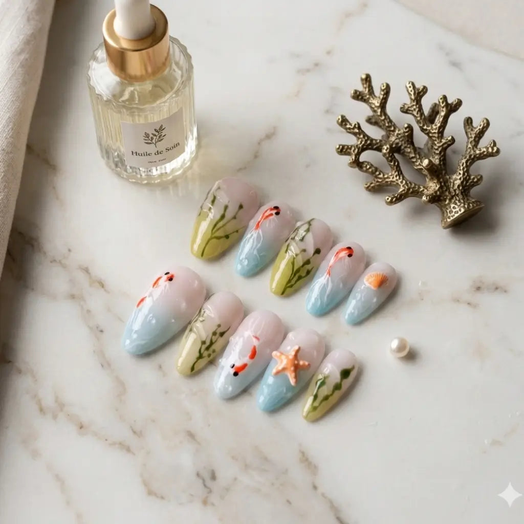 Set complet press-ons Aqua Flora design mer avec poissons koi orange, algues vertes et étoile de mer sur fond dégradé bleu.