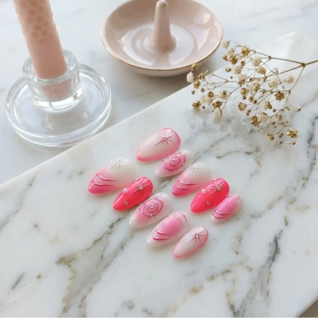 Press-on nails Candy Galaxie rose ibiza et blanc sur marbre, 8 ongles amande avec étoiles filantes et strass, décor bougie et fleurs séchées