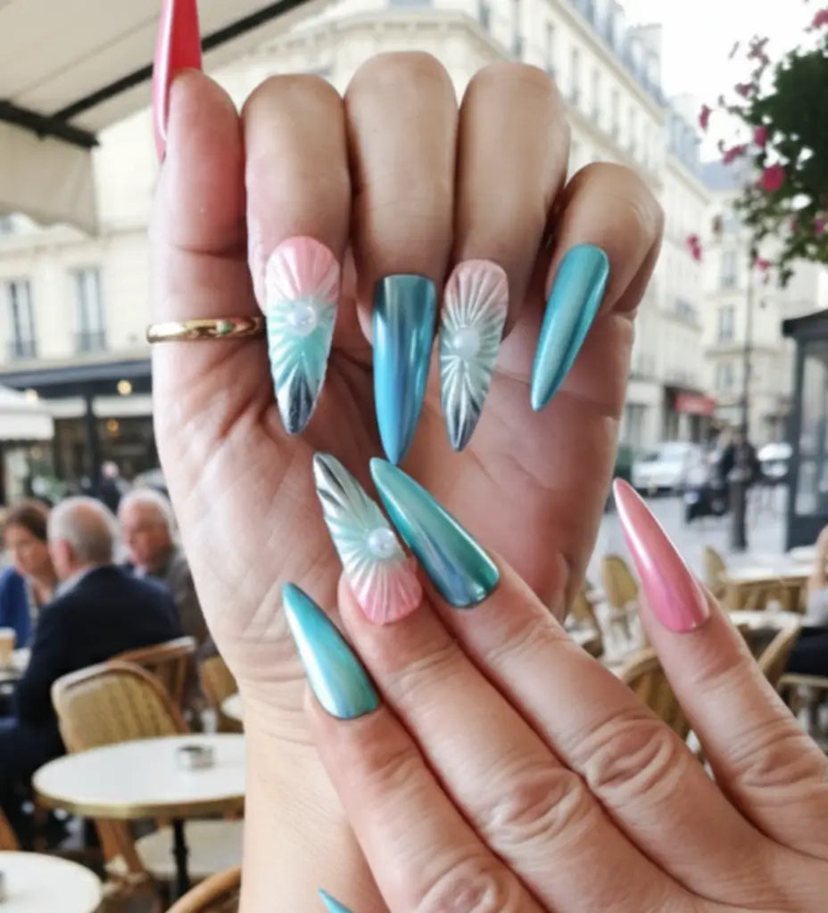 Press-on nails Sinay bleu turquoise et rose - vue portée en terrasse avec motifs coquillage 3D et strass.