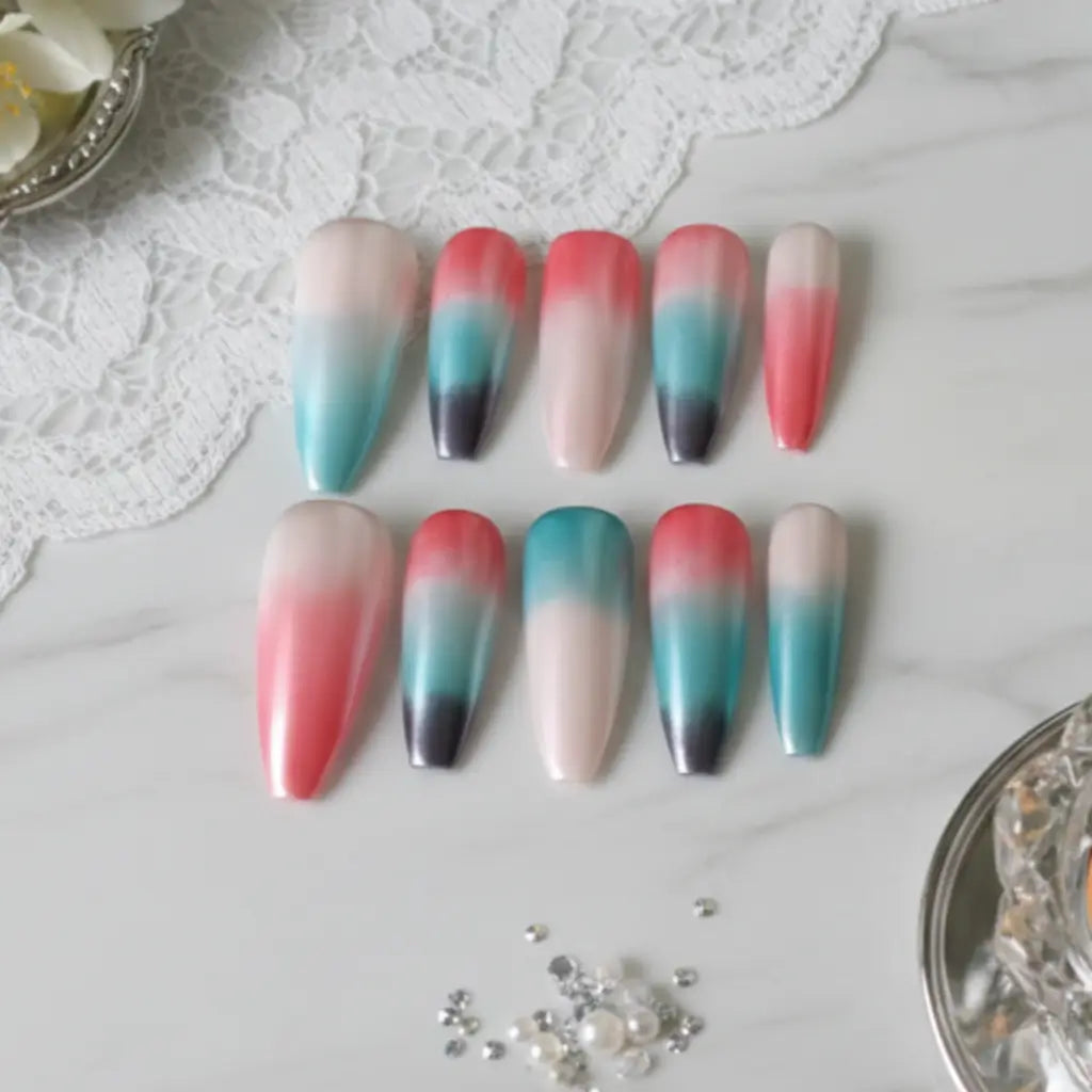 Faux ongles Sunset Lagoon avec dégradé rose corail, turquoise et noir sur marbre blanc avec orchidée et bague diamant.