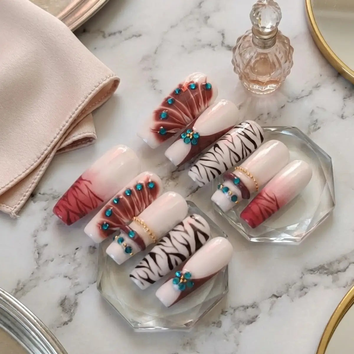 Set de press-on nails Tiger posés sur marbre montrant les détails du design