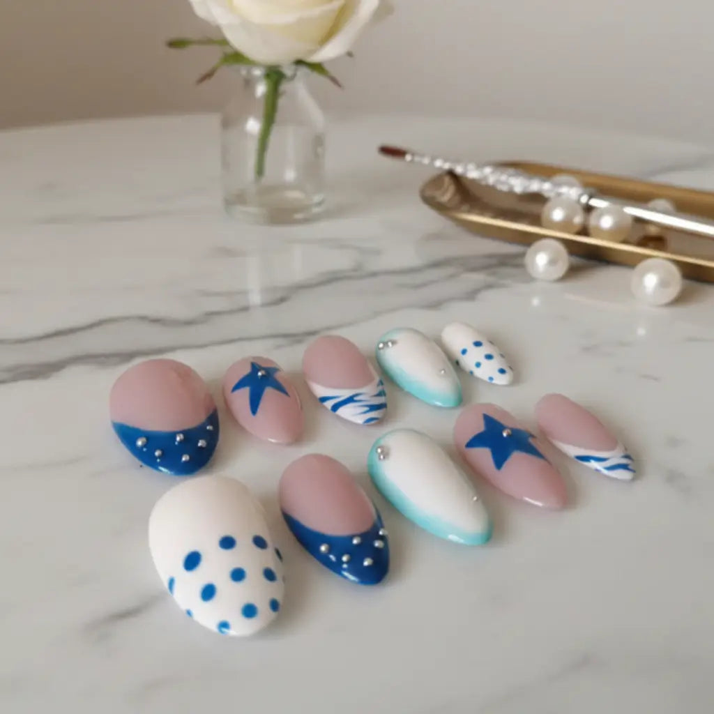 Faux ongles réutilisables Riviera Bleue faits main en France, forme amande, design nautique bleu et turquoise avec strass.