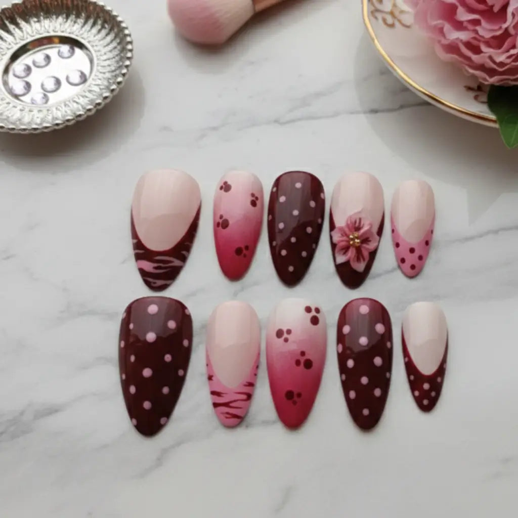 Détail faux ongles bordeaux et rose avec bague fleur dorée, ongles réutilisables non-toxiques. 