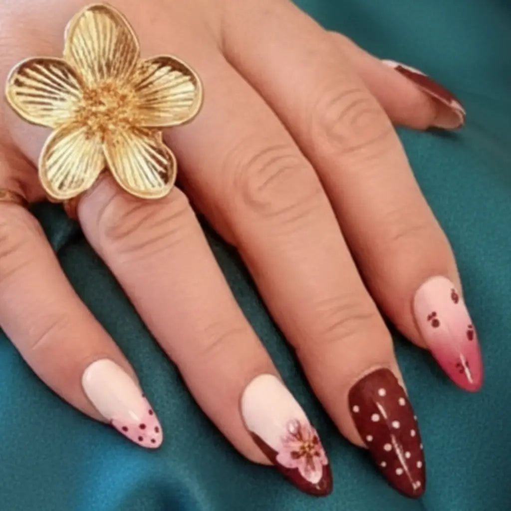 Ongles pressés artisanaux bordeaux et nude avec pois blancs et fleur rose, bague fleur dorée